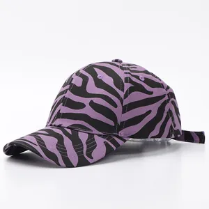 Detalle de gorra de béisbol morada con estampado de cebra, visera curva y correa