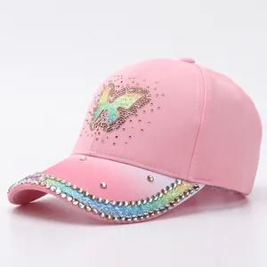 Close-up of pink baseball cap featuring rhinestone butterfly and gradient brim details