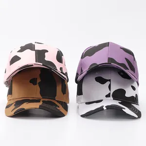 Detalle de gorras de béisbol con estampado animal en rosa, marrón, violeta y blanco