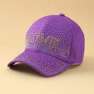 Close-up of purple baseball cap featuring LOVE rhinestone lettering and crystal accents