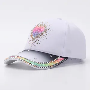 Detail of sequin heart and colorful rhinestones on a white gradient baseball cap