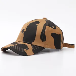 Detalle de la gorra de béisbol con estampado de vaca marrón y textura de tela de lona