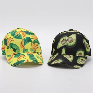 Detail of baseball caps featuring vibrant banana and avocado fruit prints on fabric