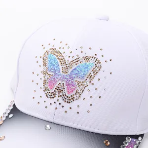 White baseball cap with rhinestone gradient butterfly and glitter heart design for women