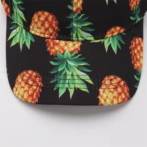 Detailed close-up of a baseball cap brim with yellow pineapple prints and reinforced stitching