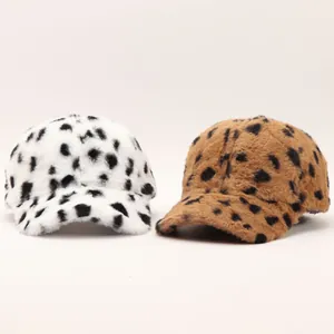 Detailed view of plush leopard print baseball caps in white and brown faux fur texture