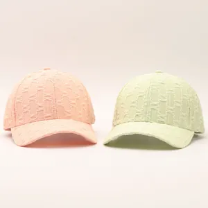 Detailed close-up of textured seersucker baseball caps in peach and light green colors