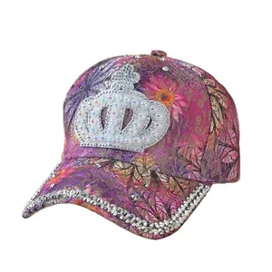 Florale Baseballkappe mit Strass-Krone und Perlen auf weißem Hintergrund