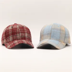 Dettaglio cappellini da baseball pied-de-poule autunno inverno in rosso-marrone e azzurro