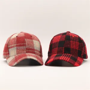Detailed view of two houndstooth baseball caps in red and grey wool blend plaid