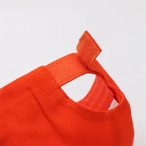 Détail de la casquette orange avec fermeture Velcro réglable et texture en sergé de coton