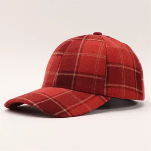 Detailed view of red and brown plaid wool baseball cap with thick textured fabric