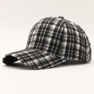 Dettaglio della trama pied de poule e della visiera curva del cappellino da baseball