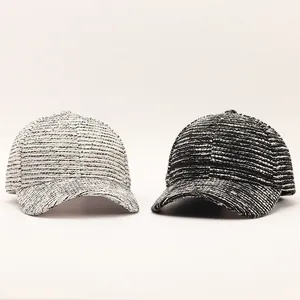 Detailed view of two tweed baseball caps showing woven black and white textured fabric