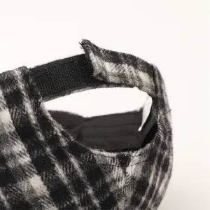 Dettaglio del cappello pied de poule con chiusura a strappo e spessa trama di lana