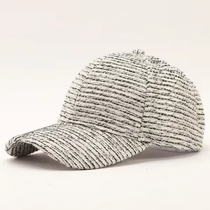 Close-up of elegant black and white tweed baseball cap with textured weave and curved brim