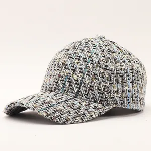 Close-up detail of luxury tweed baseball cap showing blue and gold weave texture