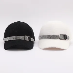 Close-up of faux mink fur baseball caps with rhinestone belts and metal buckles