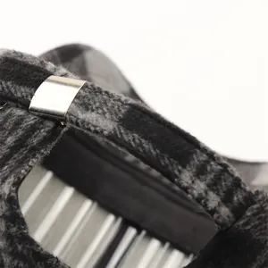Macro view of black and grey houndstooth wool fabric with adjustable silver metal buckle
