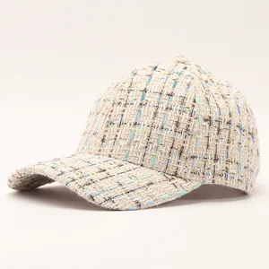 Detailed texture of tweed baseball cap with gold metallic threads and soft pastel weaving