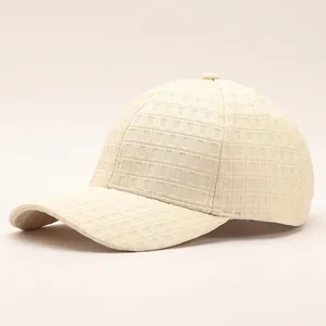 Detailed view of the waffle texture and stitching on an off-white baseball cap