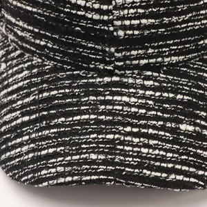 Macro detail of black and white tweed fabric texture on a minimalist baseball cap