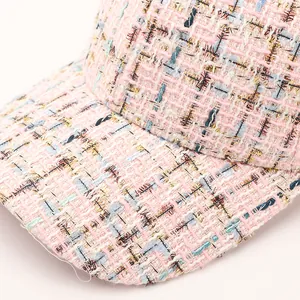 Macro shot of pink tweed baseball cap fabric with woven golden thread details