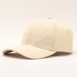 Detail of beige baseball cap featuring embossed sunflower floral patterns and curved brim