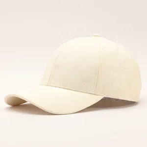 Detailed view of cream white baseball cap with 3D quilted wave pattern and curved brim