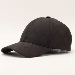 Close-up of quilted plaid baseball cap with winter textured diamond pattern on grey background