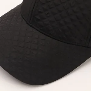 Detail of black baseball cap with embossed diamond pattern texture and stitching