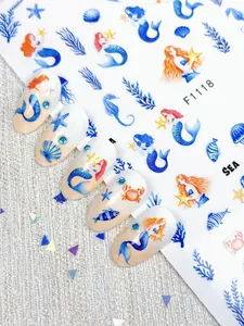 Detailed 3D nail art stickers showing mermaid and marine life patterns on nails