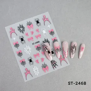 Nahaufnahme von Halloween-Nagelaufklebern mit Spinnennetzen und rosa Schleifenmotiven