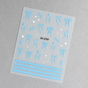 Dettaglio di adesivi per unghie con fiocchi blu e cuori bianchi modello JO-2797