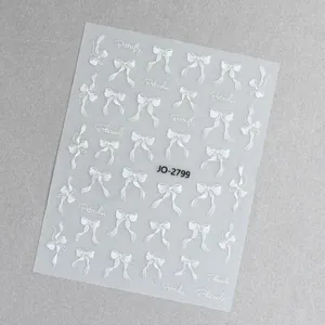 Dettaglio di adesivi per unghie con fiocchi bianchi e calligrafia d'arte JO-2799