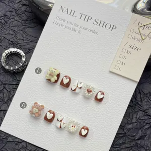 Close-up of 3D bear and heart press-on nails with pearl details and size chart
