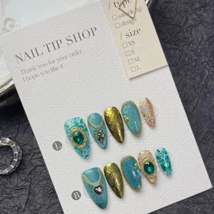 Handmade peacock green cat eye press-on nails with bronze metal charms and rhinestones