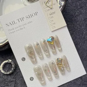 Macro view of long coffin press-on nails with cat-eye effect and 3D rhinestone heart