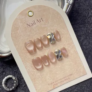 Handmade cat-eye press-on nails in nude pink with glitter gradient and cross crystal gems