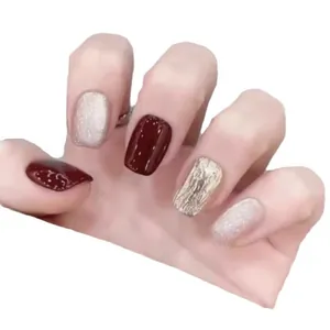 Uñas postizas ojo de gato en rojo cereza y dorado con texturas metálicas brillantes