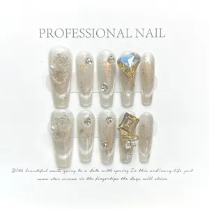 Cat eye press-on nails with white roses, pearls, and golden bows on white background