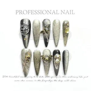 Detail of Gothic press-on nails featuring silver chains and 3D metal cross charms