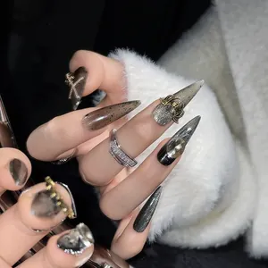 Macro shot of gothic black stiletto nails with metal chains and octopus relief
