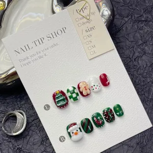 Detail of handmade Christmas press-on nails with 3D snowman and tree motifs