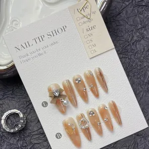 Detailed view of handmade gradient brown press-on nails with 3D bows and pearls