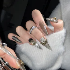 Detailed close-up of dark cat-eye press-on nails with 3D bat and rhinestone accents