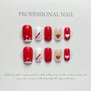 Detail view of 10-piece red and white press-on nails with cute strawberry and heart designs