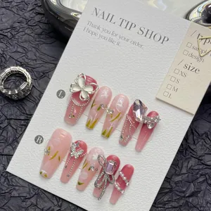 Macro shot of long coffin press-on nails with 3D silver butterflies and pink floral patterns