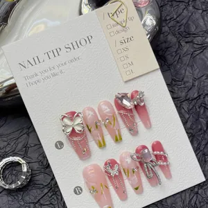 Detailed view of pink luxury press-on nails with 3D metal butterfly and pearl charms