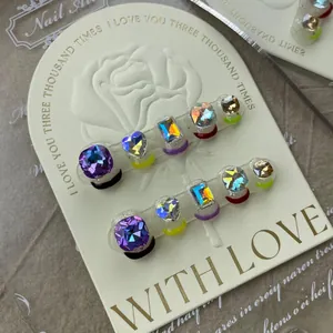 Detailed macro view of handmade dark style press-on nails with multi-color faux gemstones